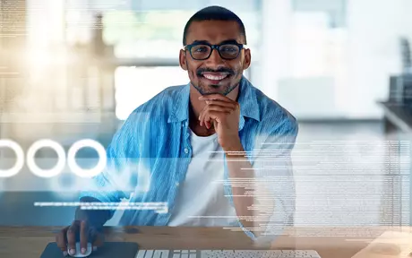 men smiling with a screen in front of him