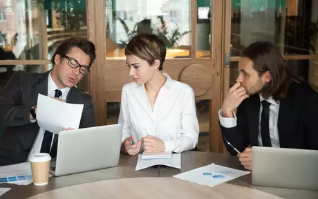 3 people seated having a meeting