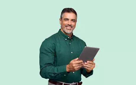 men with a tablet in his hands and smiling